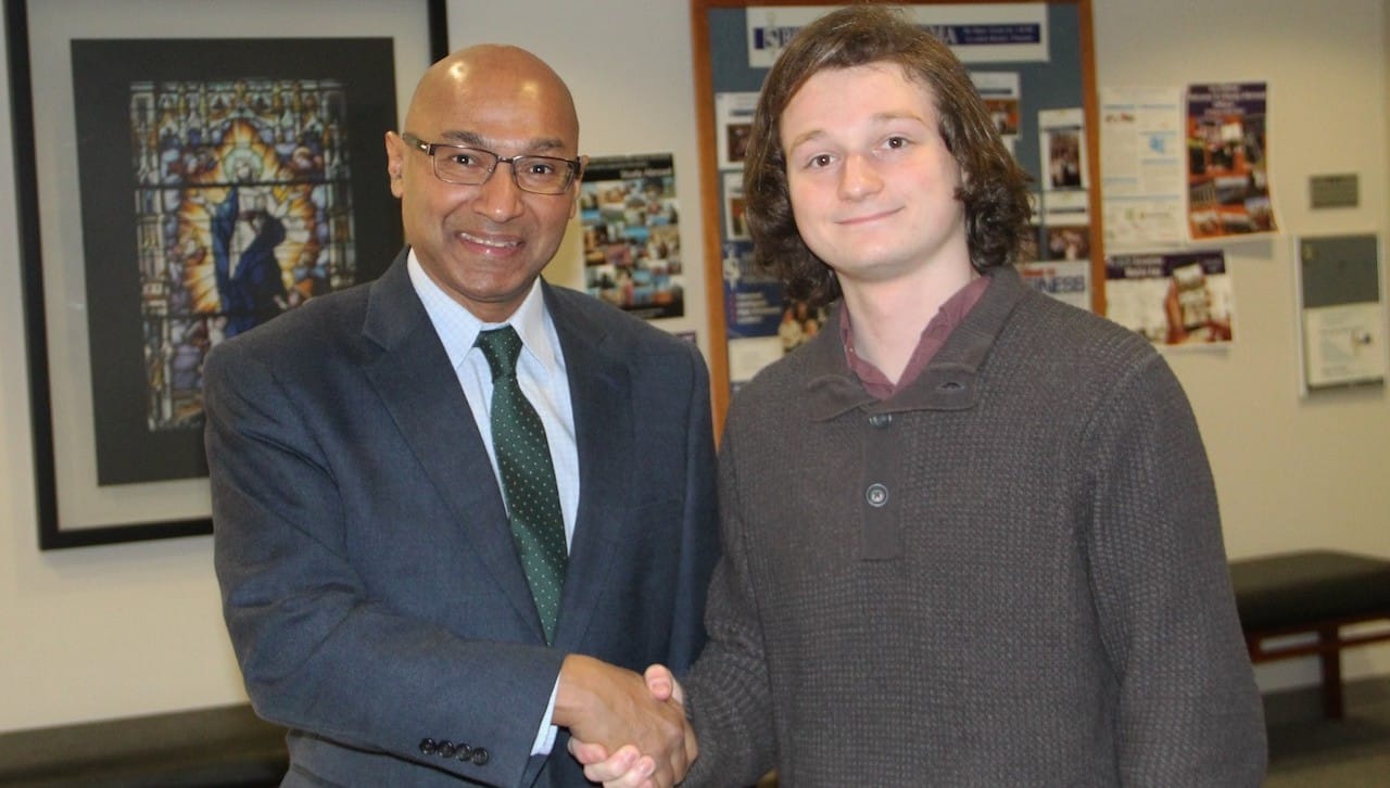 University of Scranton senior Michael Spadavecchia, Moonachie, New Jersey, received one of only four scholarships awarded in 2018 by Sigma Nu Tau, the national honor society for entrepreneurship. From left, Murli Rajan, Ph.D., interim dean of the Kania School of Management, congratulates Spadavecchia, entrepreneurship major. He was among several University students recognized recently for academic achievements.