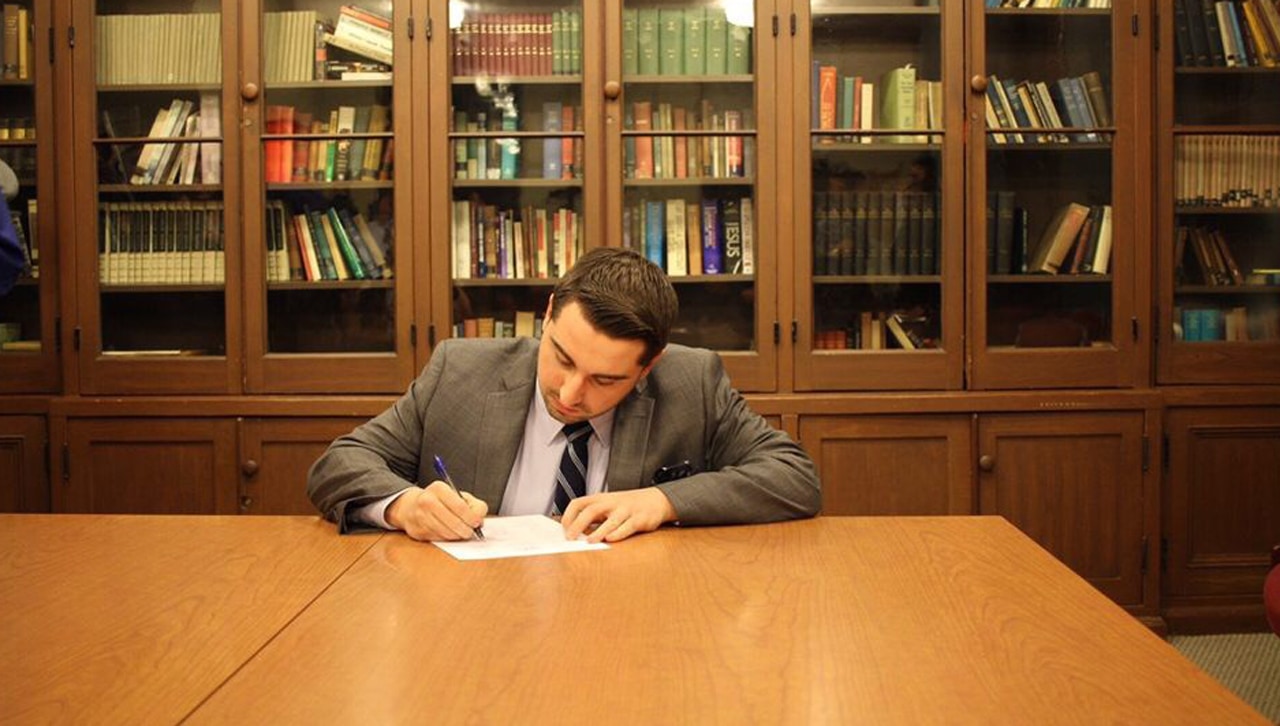 University of Scranton Student Government President Matthew Coughlin signing the Jesuit Student Government Alliance constitution as a founding member.
