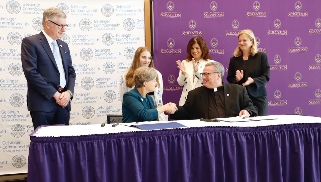 The University of Scranton and Geisinger Commonwealth School of Medicine sign a Master Affiliation Agreement to operate free medical clinic. The clinic, which adopts a “student-run” model of operation, will open to the public in January, 2024. Seated from left: Julie Byerley, M.D., M.P.H., president, Geisinger College of Health Sciences; and Rev. Joseph Marina, S.J., president of The University of Scranton. Standing: William Jeffries, Ph.D., provost, Geisinger College of Health Sciences; Madison Gladfelter, third-year medical student, Geisinger Commonwealth School of Medicine; Michelle Maldonado, Ph.D., provost and senior vice president for academic affairs, The University of Scranton; and Victoria Castellanos, Ph.D., dean of the Panuska College of Professional Studies, The University of Scranton.
