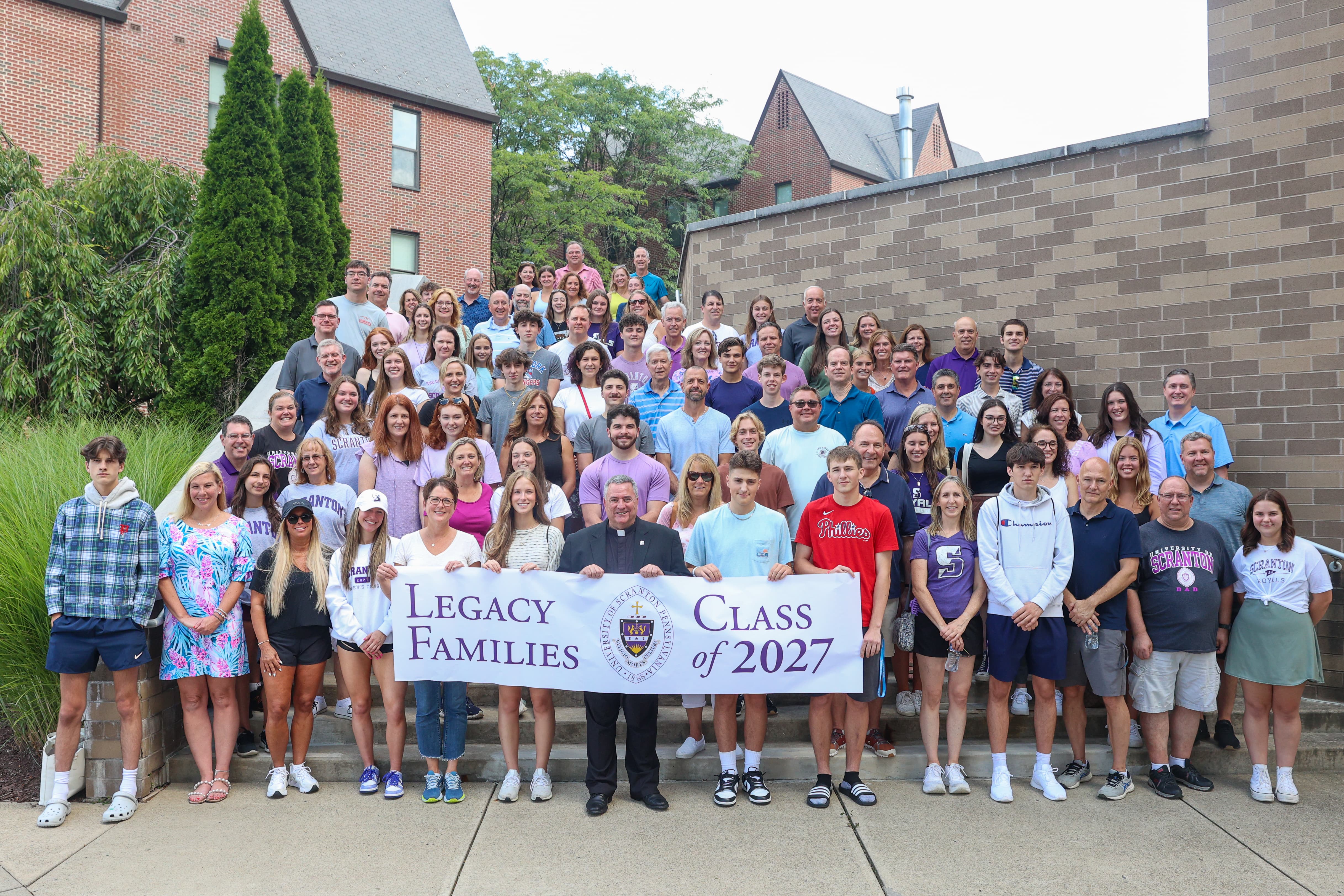 Scores of people pose together for a photo on the steps of Brennan Hall at The University of Scranton.