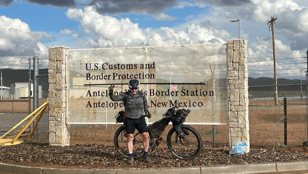 John O’Malley ’87, Lieutenant Colonel, U.S. Army Retired, enjoys a moment of triumph while finishing the Tour Divide at the U.S.-Mexico border at Antelope Wells, New Mexico, on Oct. 8, 2022.