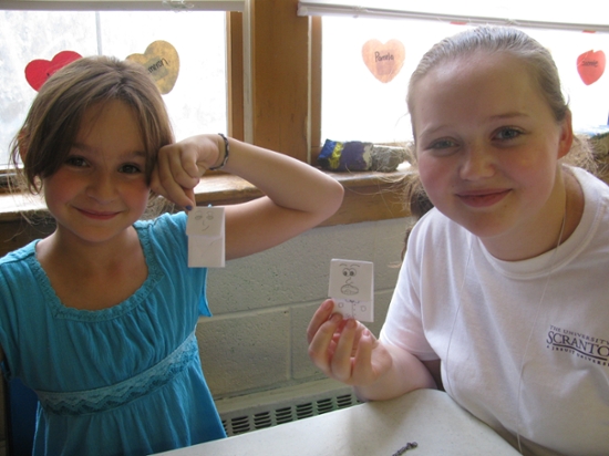 FIRST participant Anna Terry (right), a nursing major from New Milford, Connecticut, and Elyssa Lamarca, 8 years old, a soon-to-be third grade student from Scranton, show off their origami artwork at the United Neighborhood Center’s Belleview Center. Terry is among 41 incoming University of Scranton students participating in FIRST (Freshmen Involved in Reflective Service Together), a service immersion program.