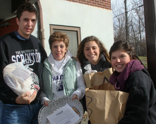 University of Scranton students, faculty and staff donated 225 food baskets for area families in need through its annual Thanksgiving Food Drive organized by the University’s Campus Ministries’ Center for Service and Social Justice. The baskets were distributed to families at the Valley View Housing Development. Among those participating are, from left: University staff members Charles LeStrange and Sheila Strickland; and University students Jacqueline Bailey of Scott Township and Chloe Strickland of Scranton. Students, faculty and staff will also volunteer at the University’s annual Community Christmas Day Breakfast from 8 a.m. to 10:30 a.m. on Dec. 25 in the DeNaples Center. Reservations are not required to attend the free breakfast. For information call 570-941-7401 or email info@scranton.edu.