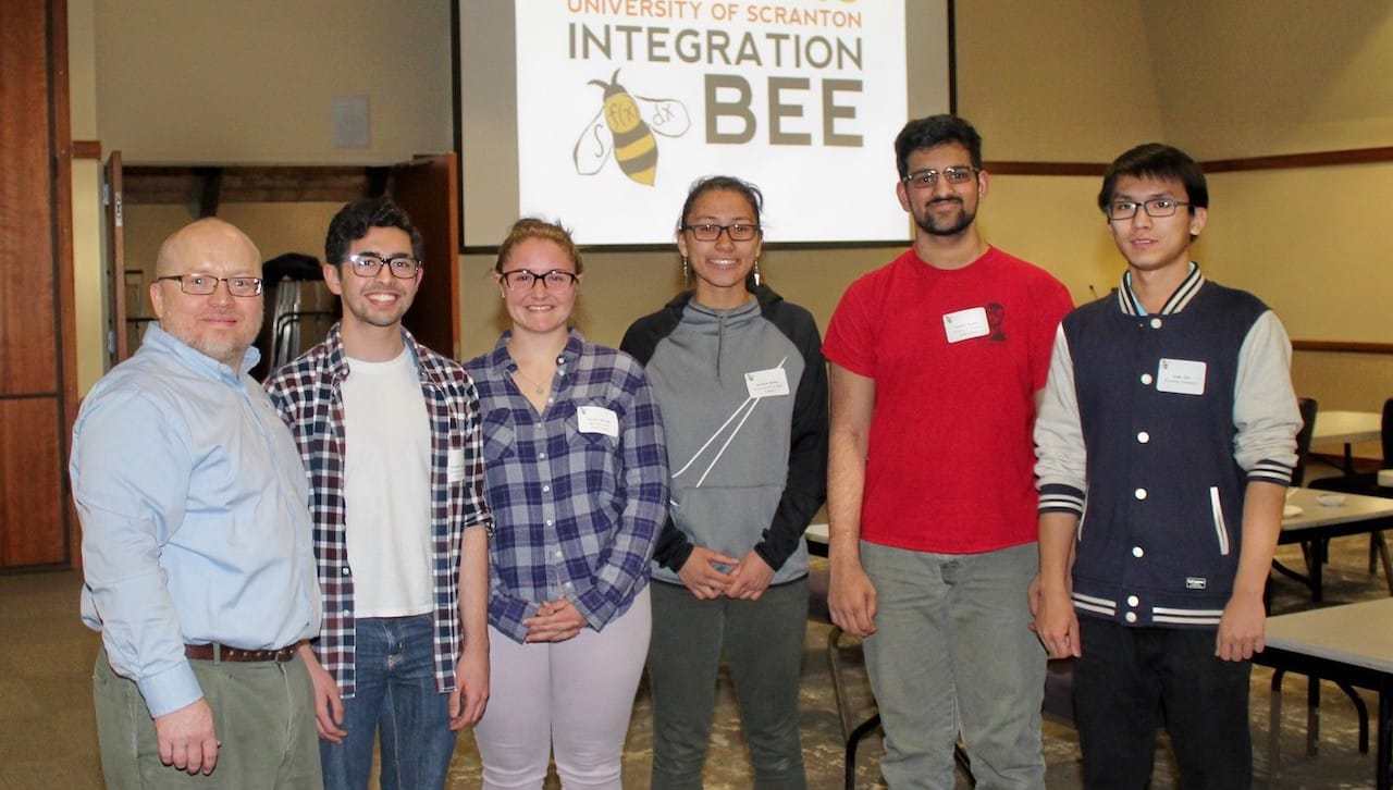 Five area high school students were the finalists in The University of Scranton’s 2018 Math Integration Bee held on campus in April. From left are: Thomas Shimkus, Ph.D., associate professor of mathematics at The University of Scranton; and finalists Mateen Kasim, Abington Heights High School; Haylee Merola, Hazleton Area Academy of Sciences; Kaitlyn Beiler, Hazleton Area High School; Vishnu Dasari, Central Columbia High School, who was the overall winner of the competition; and Andy Liz, Wyoming Seminary Preparatory School.