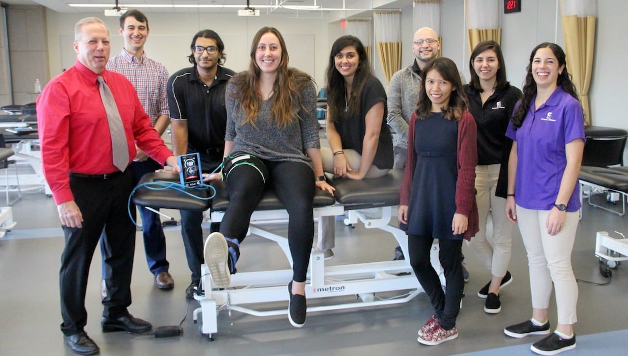 Peter Leininger, Ph.D., assistant professor of physical therapy, demonstrates blood flow restriction (BFR) therapy using the BFR Delphi unit and light-load exercise with a tourniquet, which has been shown to greatly hasten the rehabilitation process. Dr. Leininger and his students will present their BFR research (a systematic review) at the annual American Physical Therapy Association’s national conference in Washington, D.C. in January. From left: Dr. Leininger and DPT graduate students Matthew Aitken ’17, Edison, New Jersey; Omar Amer, Scotch Plains, New Jersey; Stephanie Klug, Mooresville, North Carolina (demonstrating the therapy); Berta Carmo, Parsippany, New Jersey; Jonathan Mayes, Dublin (PA); Dannylyn Manabat, Long Beach, California; Christine Kiefer ’17, Wantagh, New York; and Sophia DiCamillo ’17, Abington.