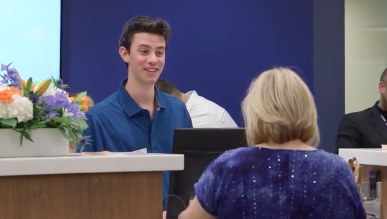 Jeffrey Colucci '21 assisting a member at the teller desk.