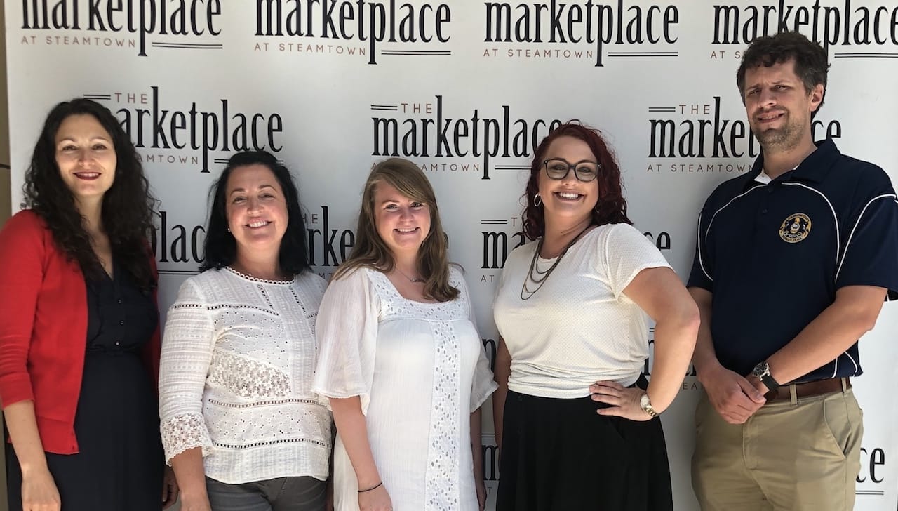 The University of Scranton and community partners will hold the eighth annual Back to School Bonanza Community Fair together with the University’s incoming class of 2023 on Sunday, Aug. 25, from 2 to 3:30 p.m. at The Marketplace at Steamtown. This event is free and open to the public. Seated from left: Julie Schumacher Cohen, director of the University’s Office of Community Relations; Tricia Cummings, program coordinator for clubs and organizations for the University’s Center for Student Engagement; Jessica Durkin, administrative assistant for the University’s Office of Community Relations; Jenn Warnetsky, general manager, The Marketplace at Steamtown; and Gerard Hetman, community relations coordinator, Lackawanna County.