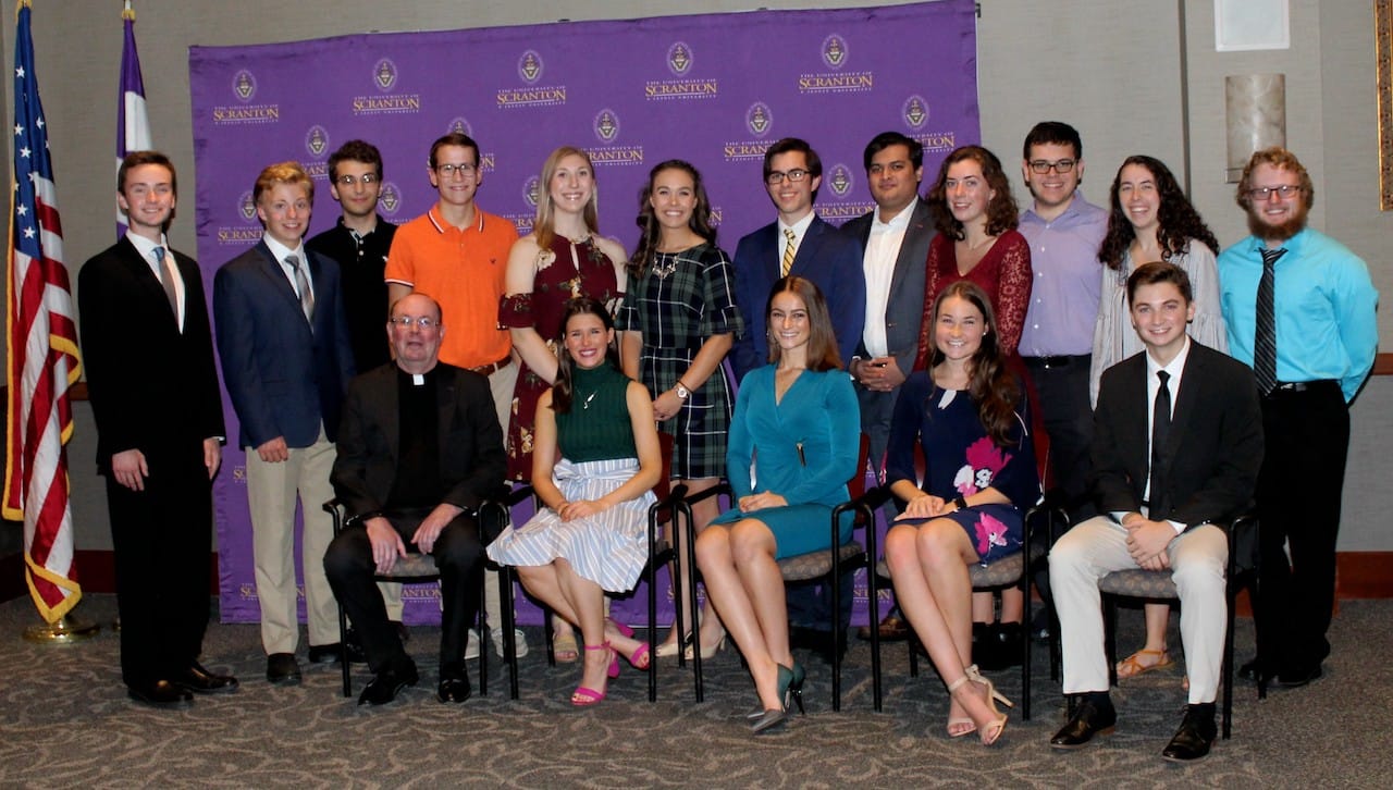 Eighteen students from the University of Scranton class of 2023 have been awarded four-year, full-tuition Presidential Scholarships. Seated, from left, are Rev. Scott R. Pilarz, S.J., president of The University of Scranton; and Presidential Scholars Claire Sunday, Angela Hudock, Emily Amershek and Dominic Finan. Standing: Presidential Scholars Michael Quinnan, Cameron Shedlock, James Lanning, Matthew Earley, Sarah Liskowicz, Lauren Cawley, Daniel Zych, Muhammad Shaaf Sarwar, Molly Neeson, Timothy Gallagher, Kathleen Wallace, and Michael Edwards. Not pictured are Presidential Scholars Amanda Lamphere and Jared Fernandez.