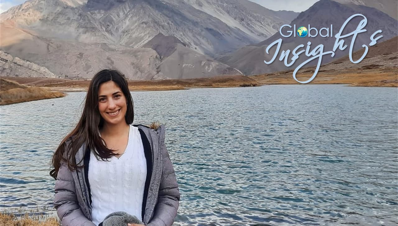 Magali Ferrer, Fulbright Scholar and graduate teaching assistant of Spanish 101, in front of a towering mountain range in Argentina.