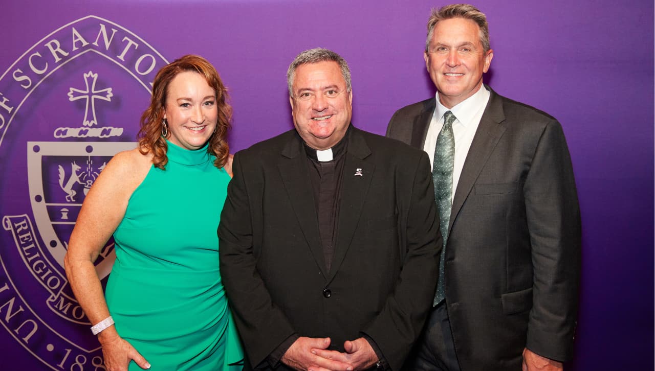 Patti Byrnes Clarke '86, P'17, '19, Rev. Joseph G. Marina, S.J., University President, and Tom O'Brien '86, P'19 enjoy a moment together at the PBC 21st Annual Award Dinner at Gotham Hall Sept. 29. 