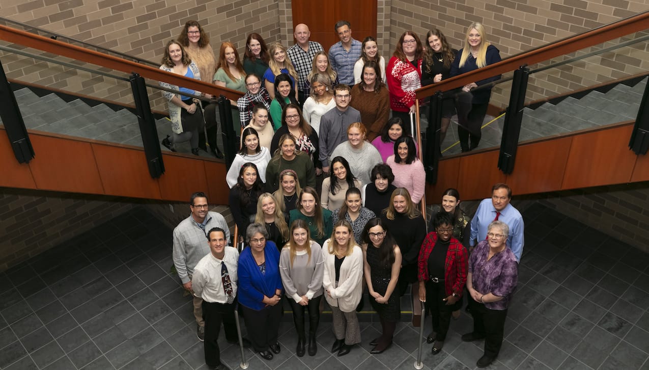 Twenty University of Scranton education majors who served as student teachers during the fall semester gathered in December with their cooperating teachers and faculty and staff of the Education Department at the University. First row, from left: Dave Angeloni, director of field placement at Scranton; Ann Marie Barhight; Laura Scanlon; Karen Degnan; Maria Oreshkina, Ph.D., associate professor and chair of the Education Department at Scranton; Tata Mbugua, Ph.D., professor of education; and Paula Brennan, adjunct education faculty member. Second row: Scott Reilly, assistant director of field placement at Scranton; Blaire Adams; Laura Schultz; Jordan Czap; Casey Ehnot; Rebecca Sullivan, education faculty member; and Russ Owens, adjunct education faculty member. Third row: Emily MacMillan; Katie Calvert; Sophia Marlow; and Mary Theresa Clister. Fourth row: Jenny Noll; Sara Amendolaro; Anna Trojan; and Michele Walsh. Fifth row: Bridget Warren; Christine McDermott; Jack Lear and Gina Grebas. Sixth row: Jess Notari; Summer Klikus; Cassie Colozza; and Ashley Coviello. Back row: Andrea Filachek; Tracey MacCallum; Abigail Knobler; Lisa Gibbons; Sofia Muta; Thomas Hornlein; Kayla Masterson; Paul Zaffuto; Danielle Raffa; Mary Alice Raider; Kelly Bierals and Alyssa Bohenek. Absent from photo were: University students Khadiga AboBakr and Julia Mancuso; and co