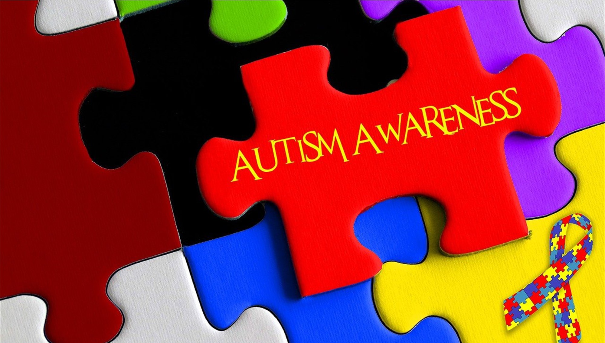 assorted solid color puzzle pieces with Autism Awareness text over the top, and a colorful puzzle piece awareness ribbon. 