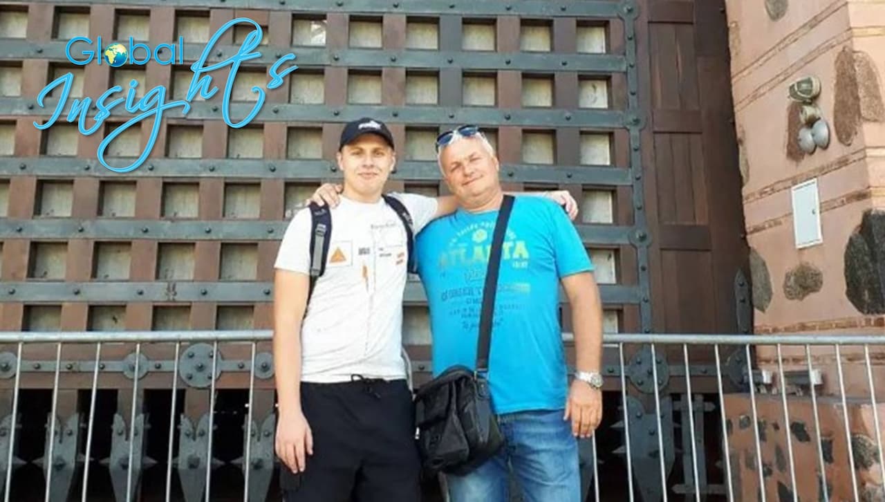 Serhii Kuzmin and his father, also Serhii, in Kyiv, Ukraine, standing in front of a large brown building.