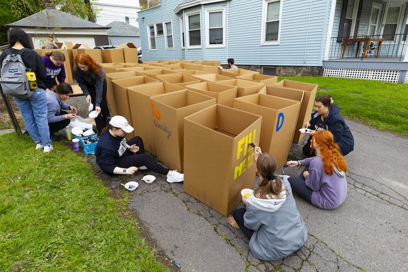 students holding decorated moving boxes