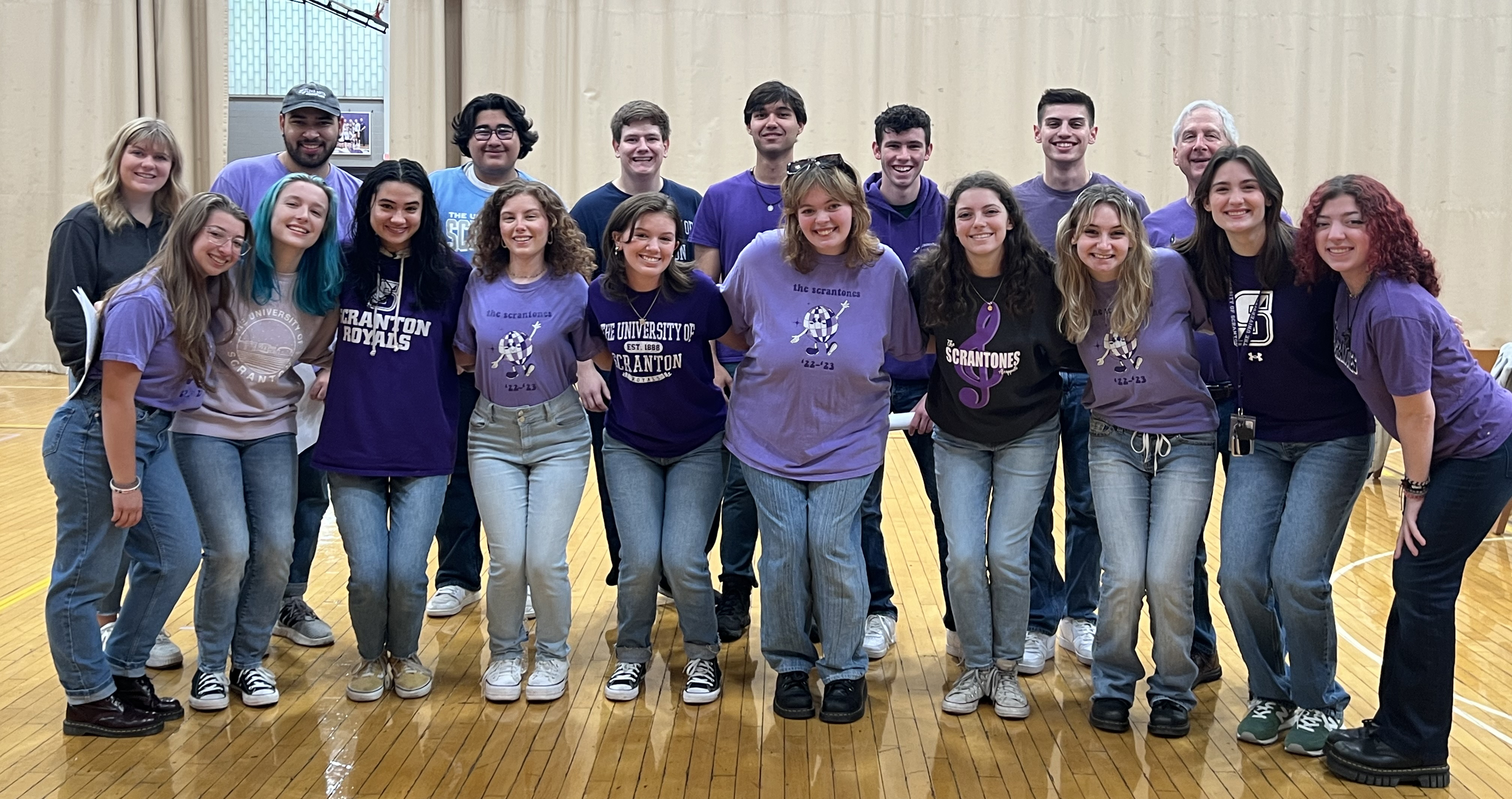 group of students wearing purple shirts pose for a photo