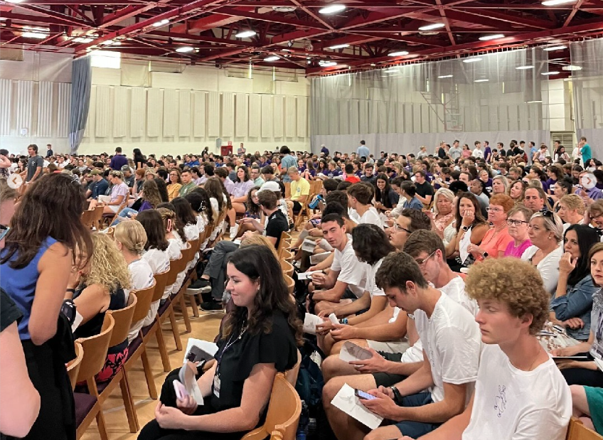 crowd seated in an assembly format in a gymnasium