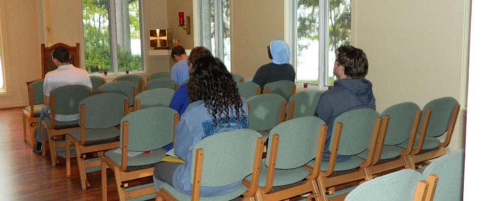 student sit in Chapman lake Chapel in prayer