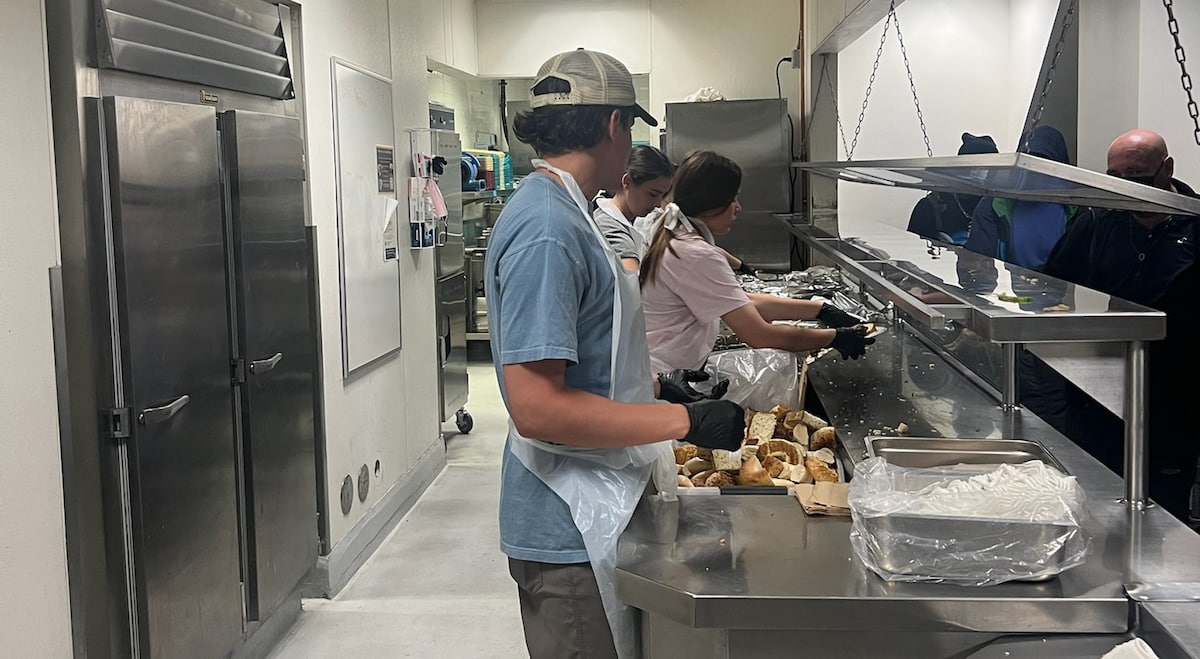 workers in a kitchern with stainless steel countertop