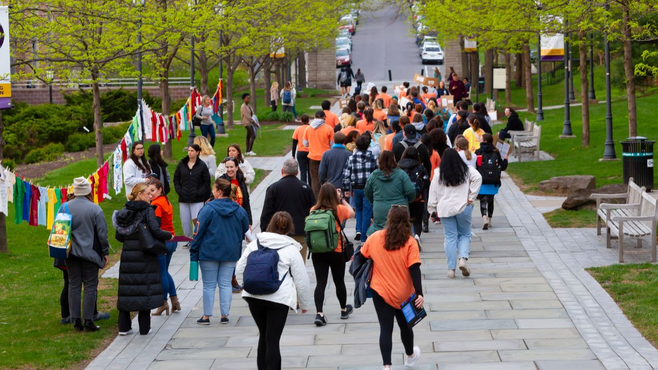 peolpe march down university commons