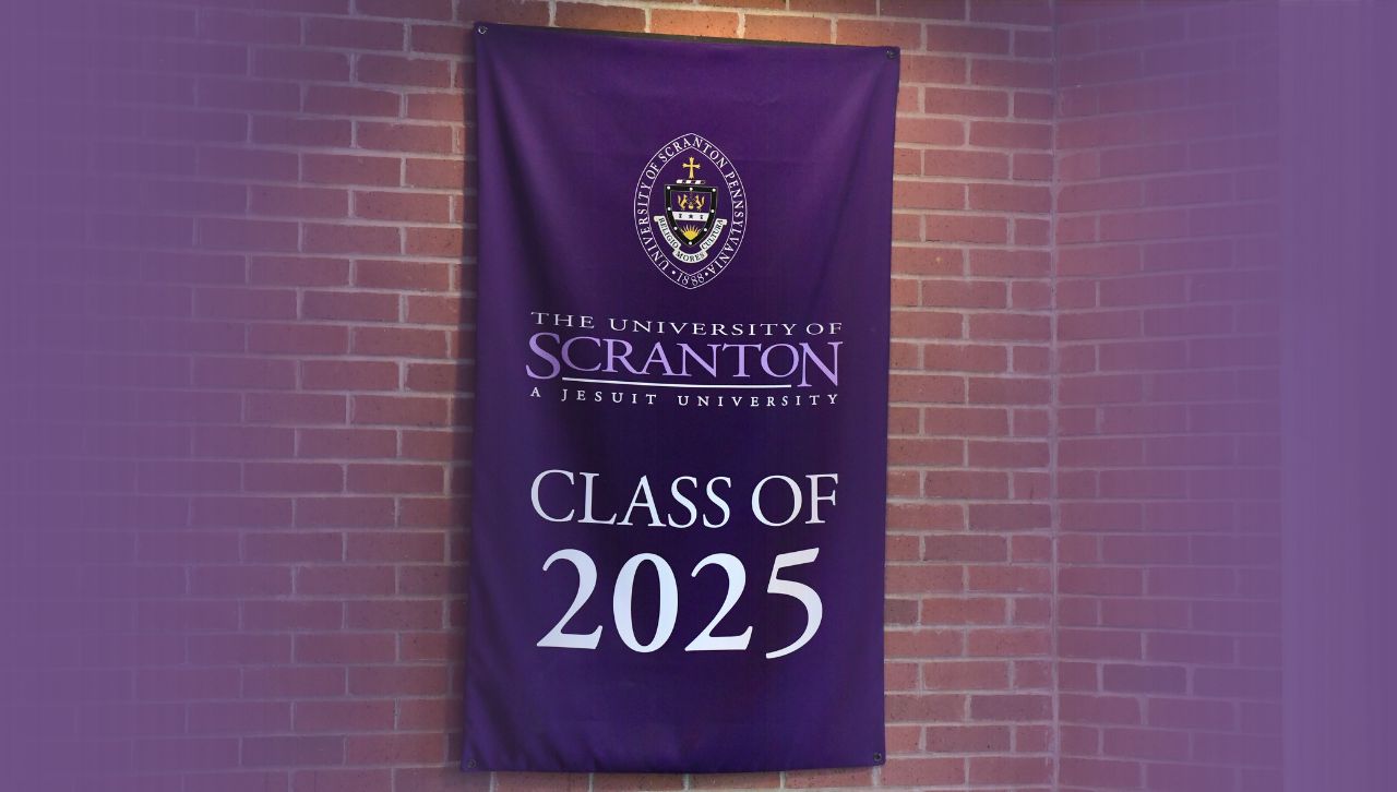 a banner reading university of scranton class of 2025 hangs against a brick wall
