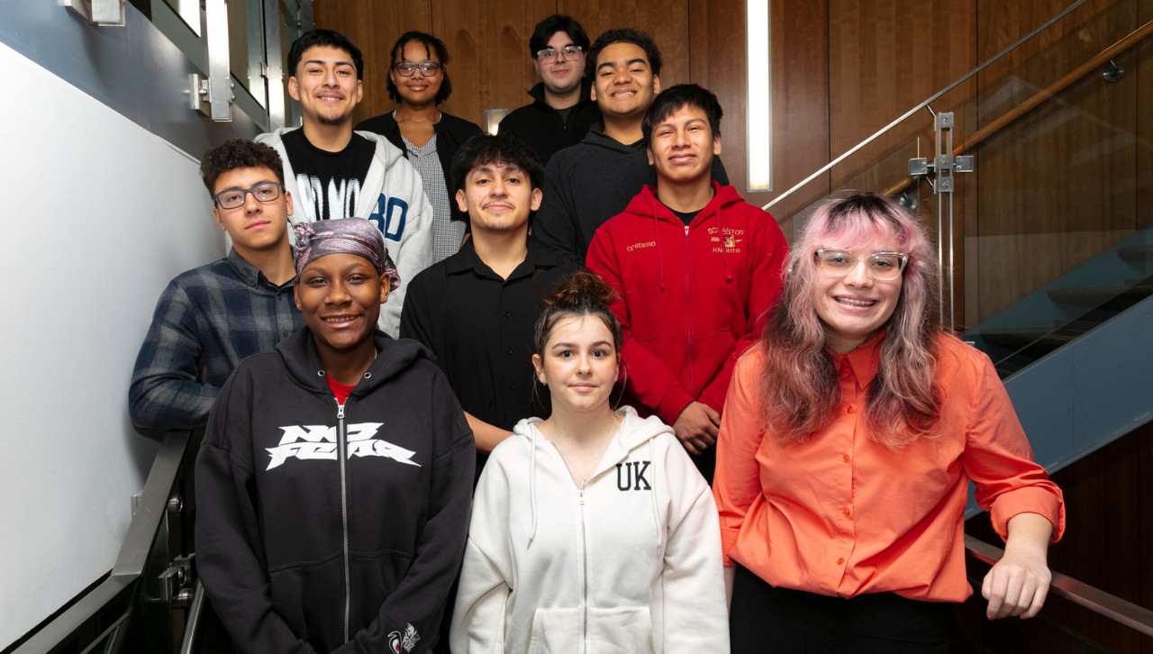 a group of individuals line up for a posed photo on a set of stairs