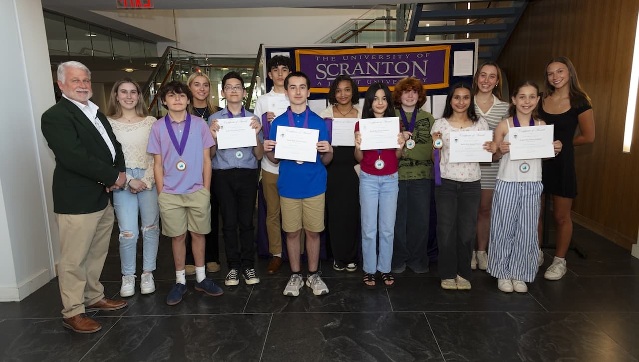 The University of Scranton announced the medalists of its Earth Day Essay Contest for students in grades 5 to 12 at an Evening of Environmental Science event on campus in April. Pictured from left, Mark Murphy, director of the Office of Sustainability at the University; Amelia Farry, a criminal justice major; Chris DeNaples from St. Claires/St. Paul’s Elementary School; Alexa Cutter, a media production and journalism major; Sean Kiernan, Ian Ferriera, and Dante DeVitto, all from Howard Gardner Multiple Intelligence Charter School; Veronica Herrera Acosta from West Scranton High School; Rosalie Edelstein, Benny Hynds and Divya Timsina, all from Howard Gardner; Samantha Kosmar, an environmental science major; Lila Tschampel, from Howard Gardner; and Rebekah Thompson, an occupational therapy major.