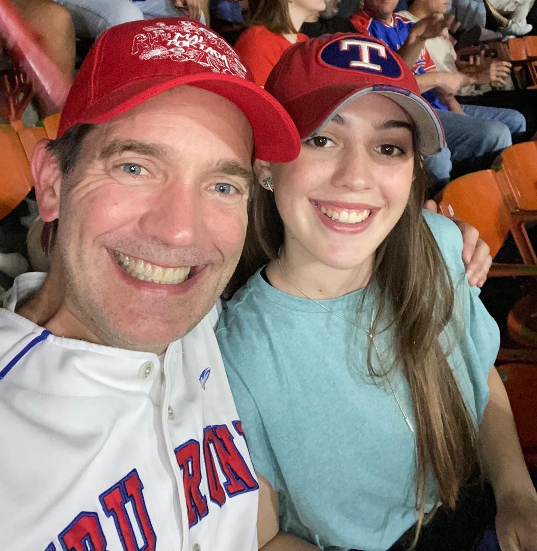 young woman with father at baseball game