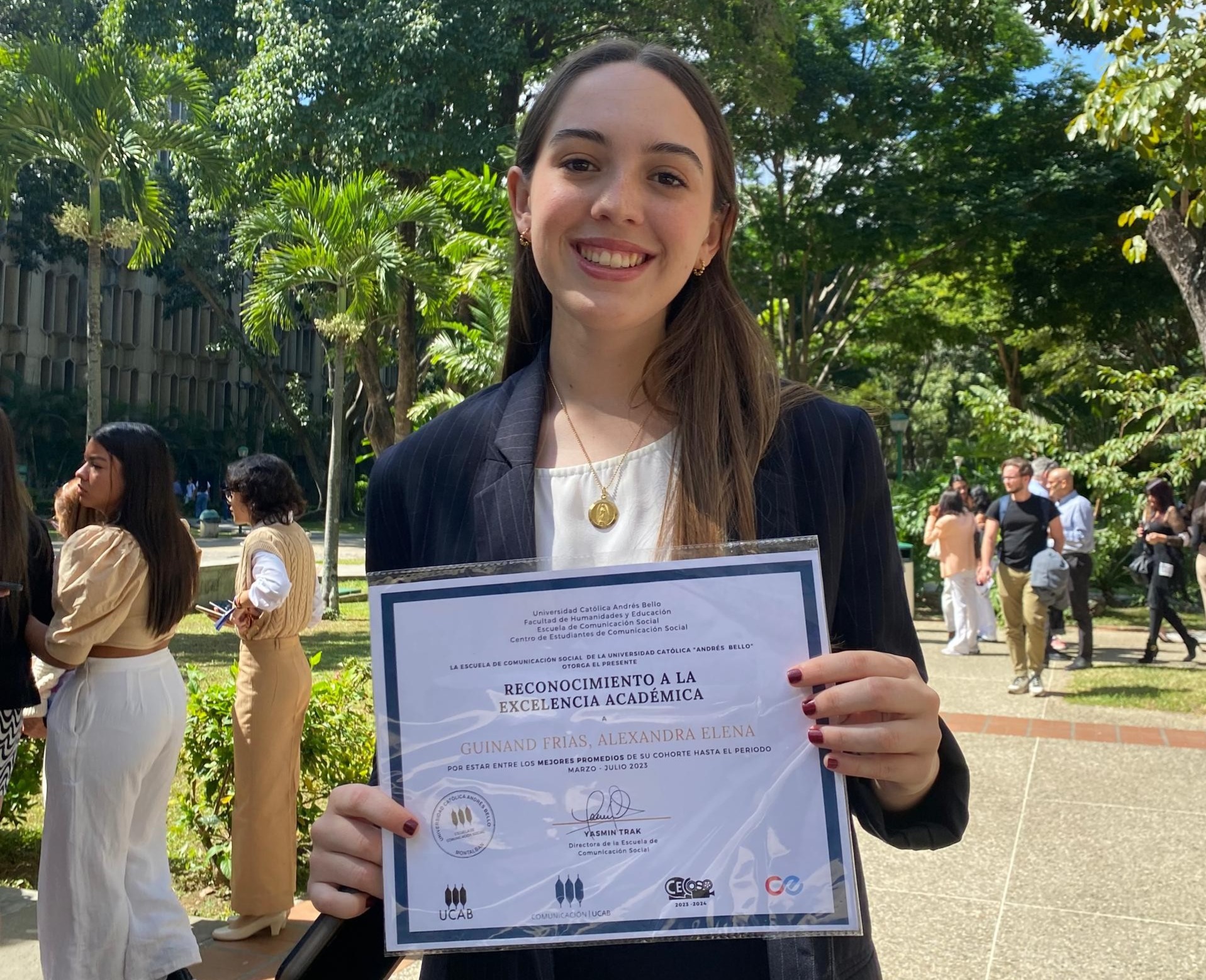 Alexandra Guinand dressed in business attire holding diploma