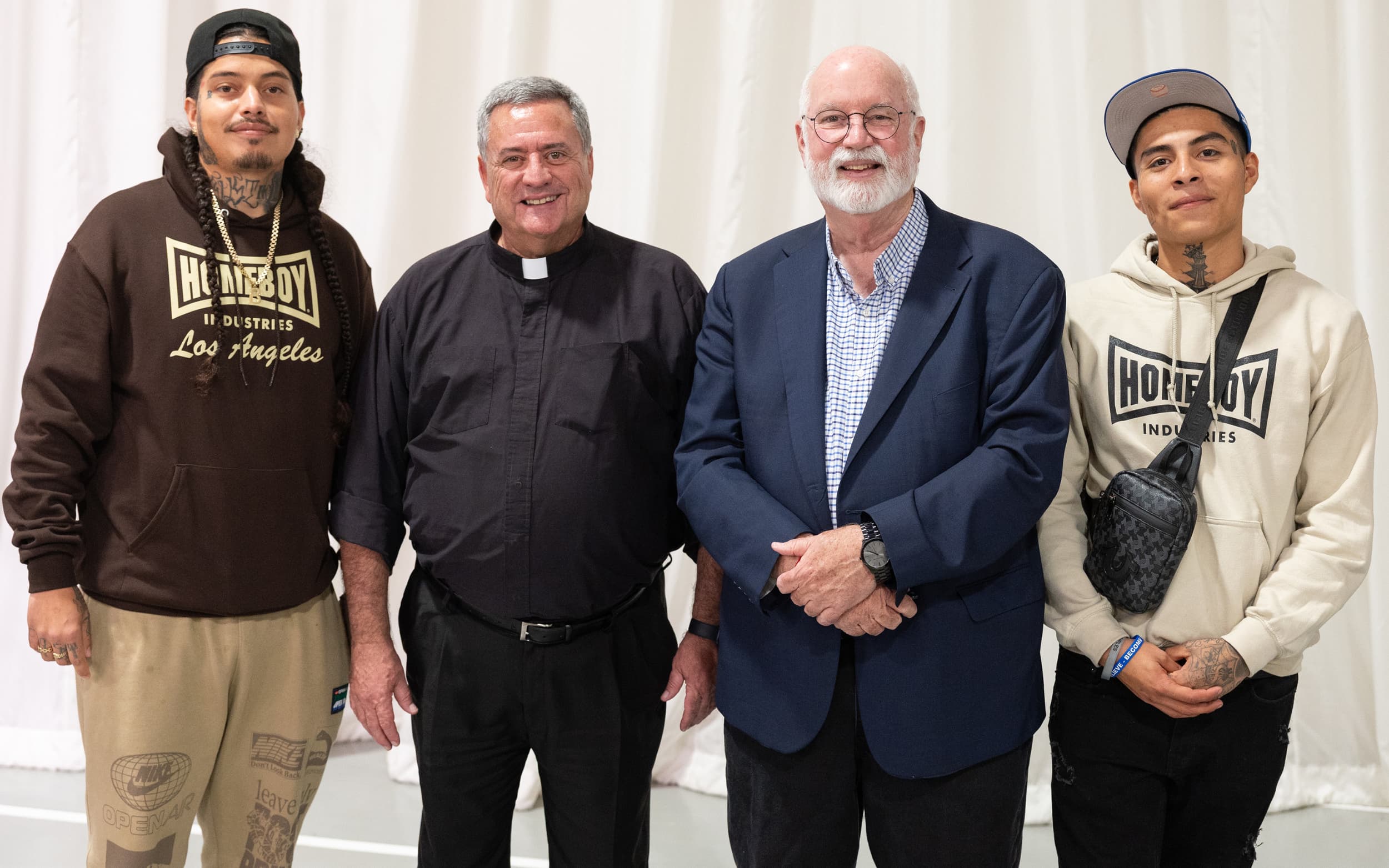 Four individuals stand together smiling for a group photo.