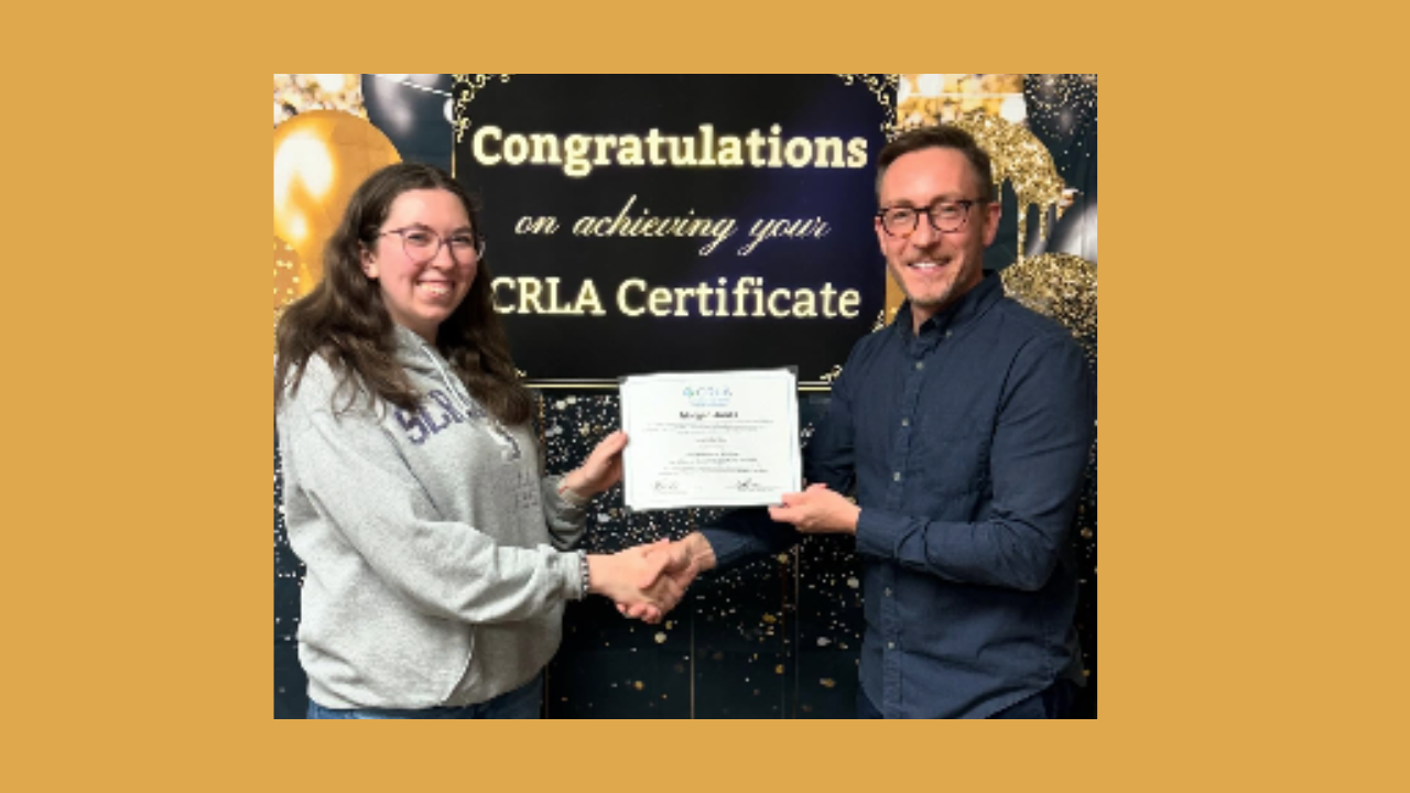 woman and man in front of a celebratory banner