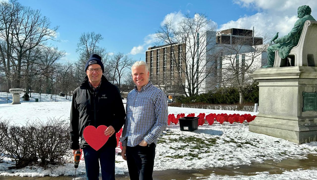 From left, Frank Dubas ’75, president of Garden of Cedar, and Tim Holmes ’88, CEO of the Everhart Museum, plant Valentine messages on the lawn of the Everhart Museum.