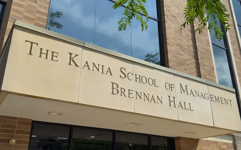 Building entrance sign reading “The Kania School of Management, Brennan Hall.”