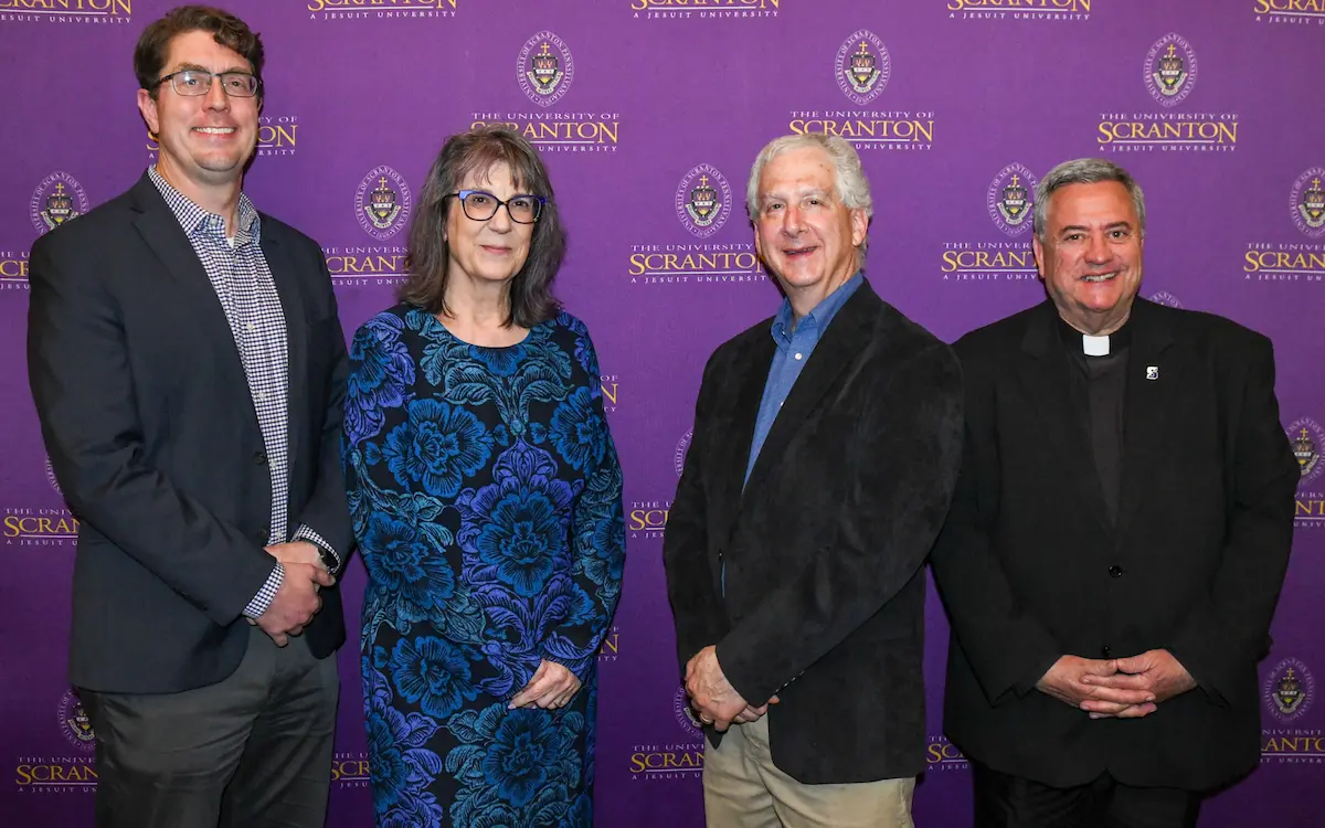 A gallery of images of individuals posing for photos in front of a purple, University of Scranton-branded backdrop.