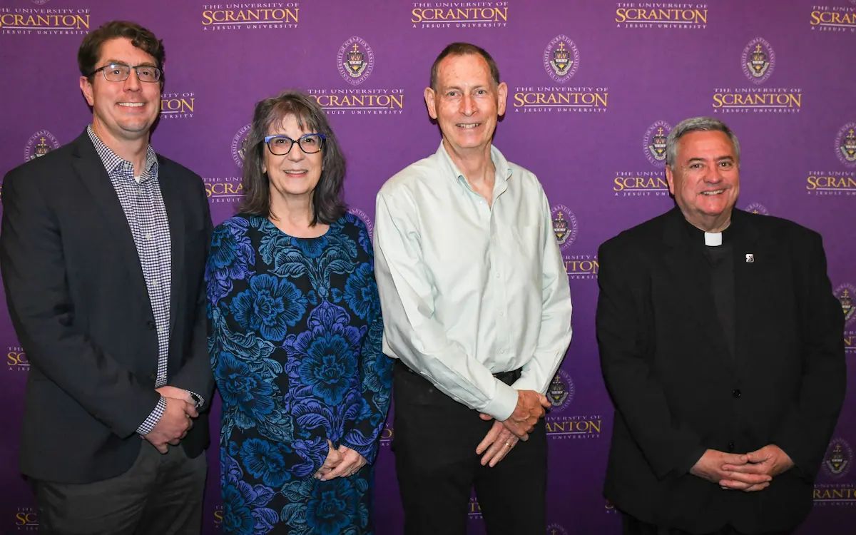 A gallery of images of individuals posing for photos in front of a purple, University of Scranton-branded backdrop.