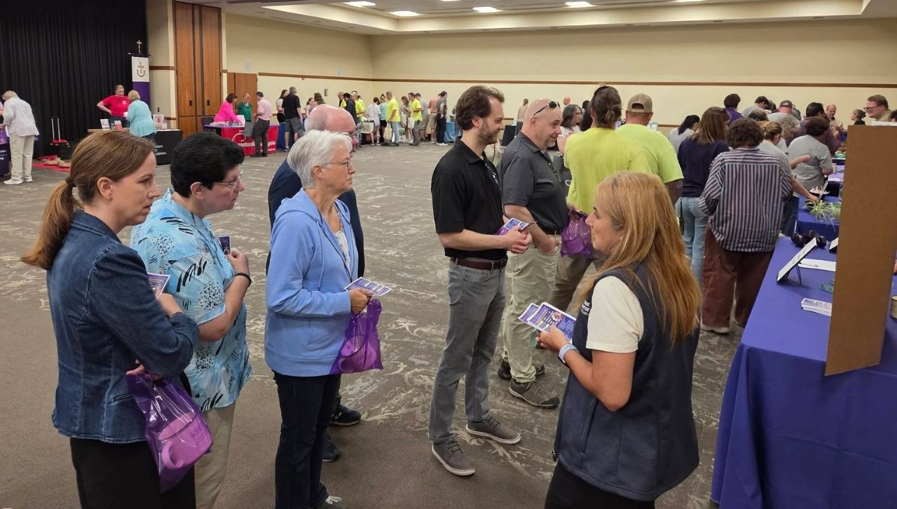 people wait in line to visit information tables at wellness fair