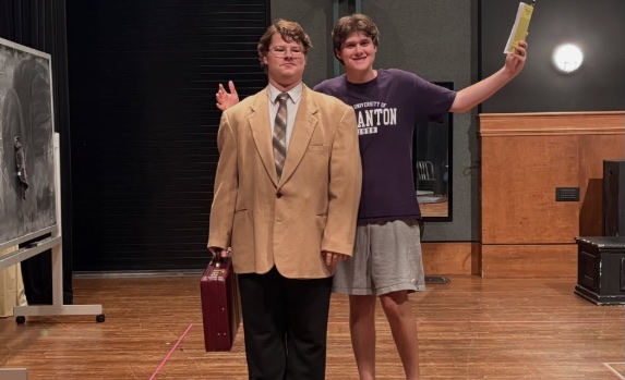Photos from a theater rehearsal, showing two students onstage with one student in a suit holding a briefcase while the other gestures with a book.