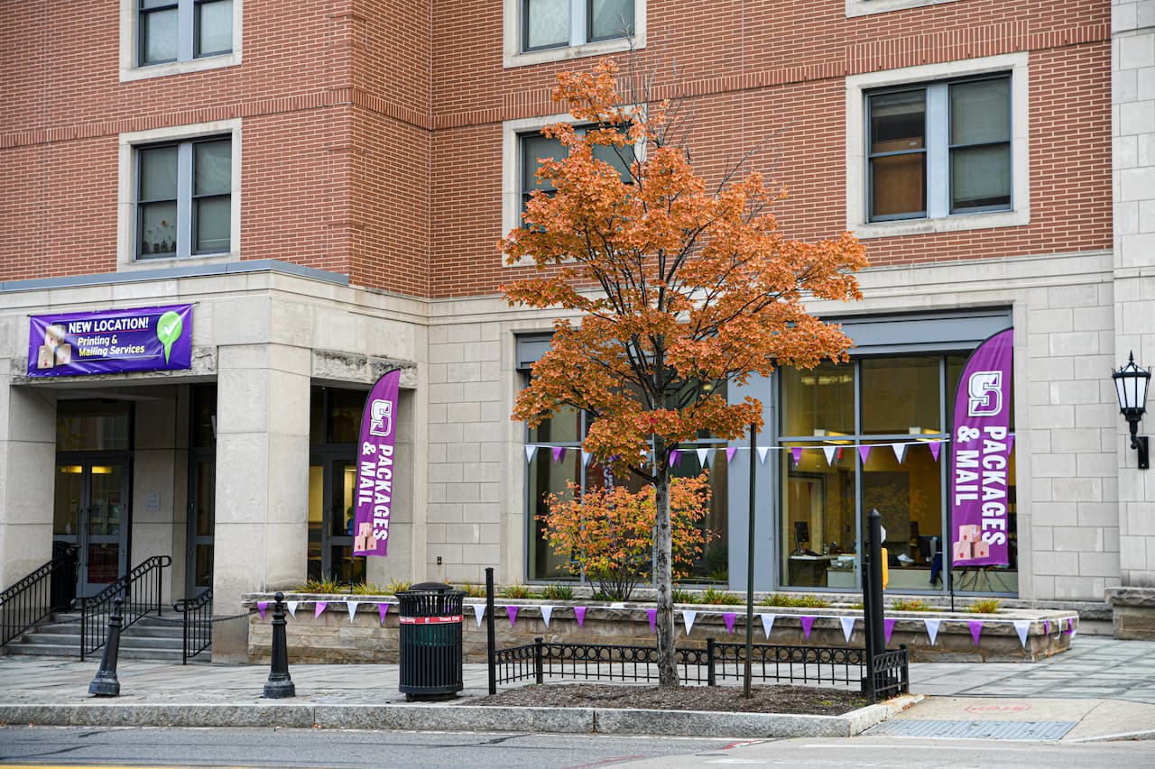building front with glass windows, purple banners announcing printing and mailing