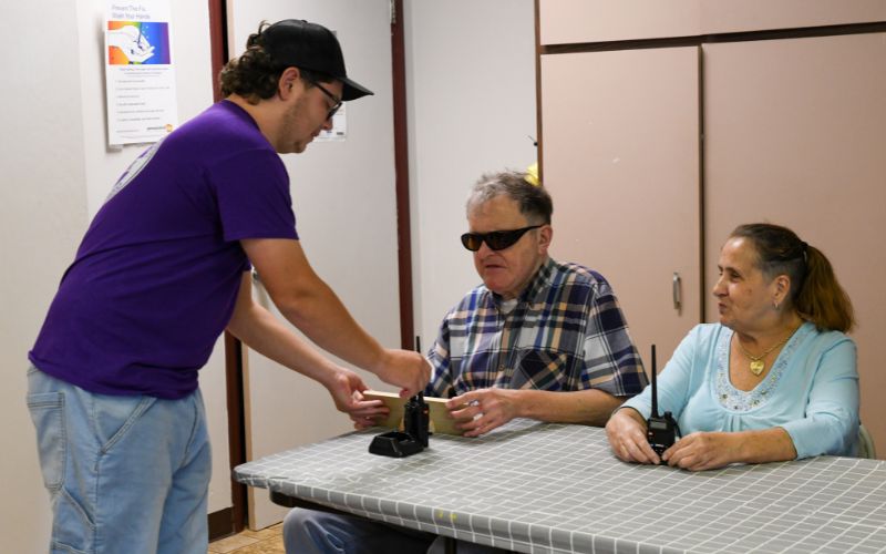 A gallery of images showing volunteers and Lackawanna Blind Association clients working together and celebrating their accomplishments.